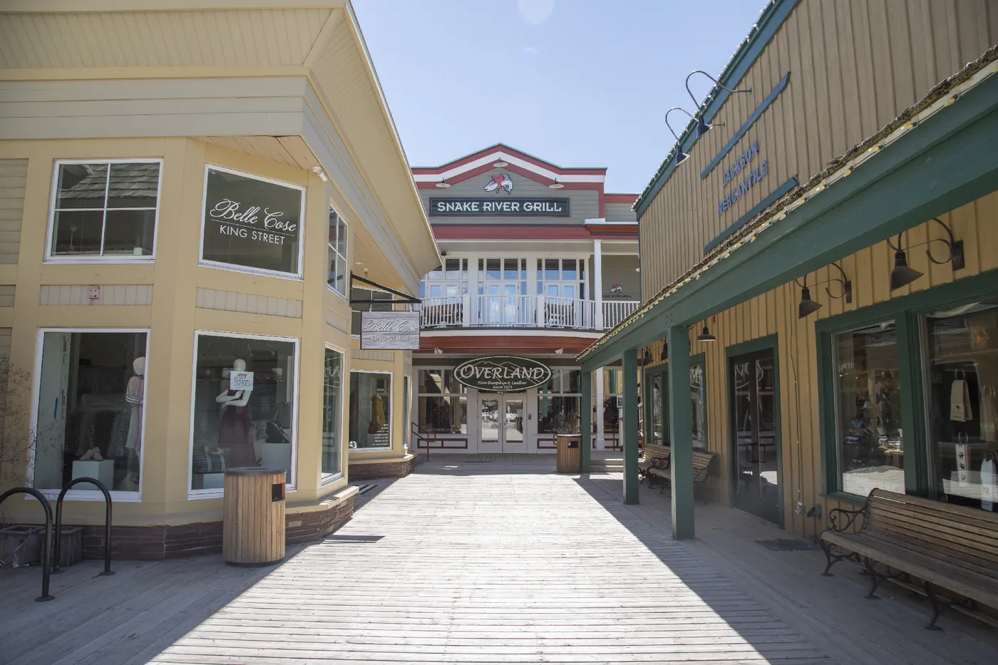 Storefronts along a sunny wooden boardwalk in downtown Jackson.